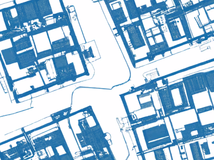 A stylized blue-and-white aerial illustration of city blocks shows building footprints and streets arranged in a grid-like pattern.