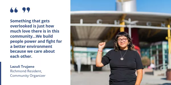 Lazuli Trujano, Richmond resident and community organizer, standing outdoors raising her fist in a gesture of solidarity.